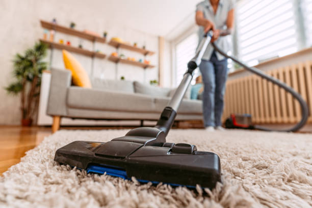 Entretien complet de la maison — aspirateur sur tapis dans un salon lumineux